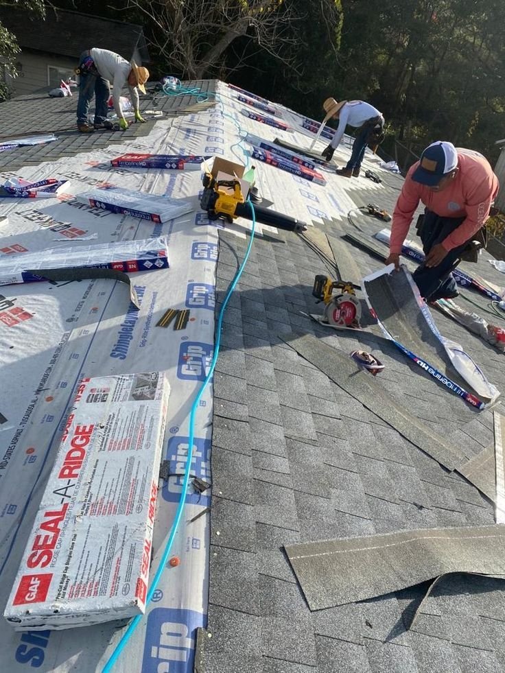 Equipo de techadores instala tejas asfálticas en el techo inclinado de una vivienda.